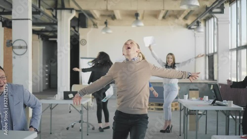 A young manager enters the office, dances, scatters documents. Colleagues get up from work, go and dance together. Corporate party. Start of vacation. The end of the work. Office life. Business