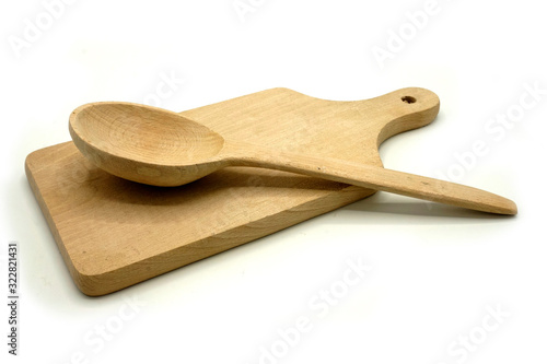 Wooden kitchen utensils on white background. Handcrafted cutting board and spoon.