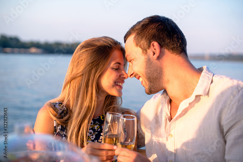 Young couple drinking champagne on the boat