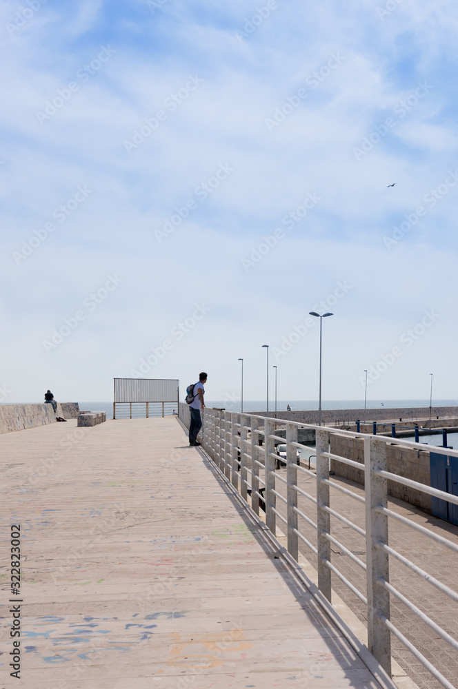Adult man visits the city of Bari, view from the pier, Italy