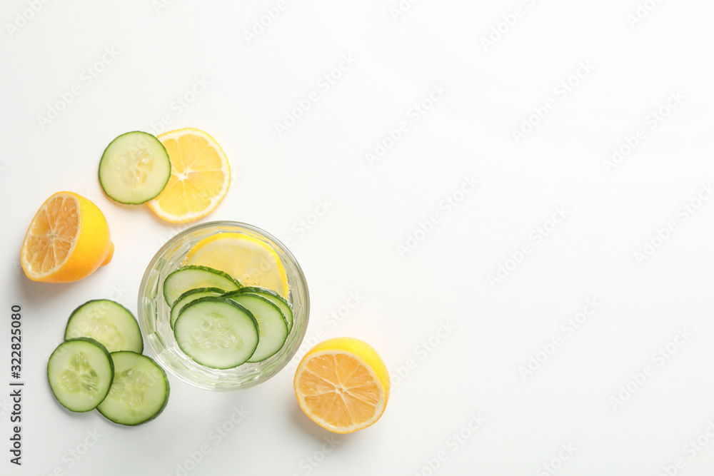 Glass with infused water, cucumber and lemon slices on white background, copy space Glass with infused water, cucumber and lemon slices on white background, copy space