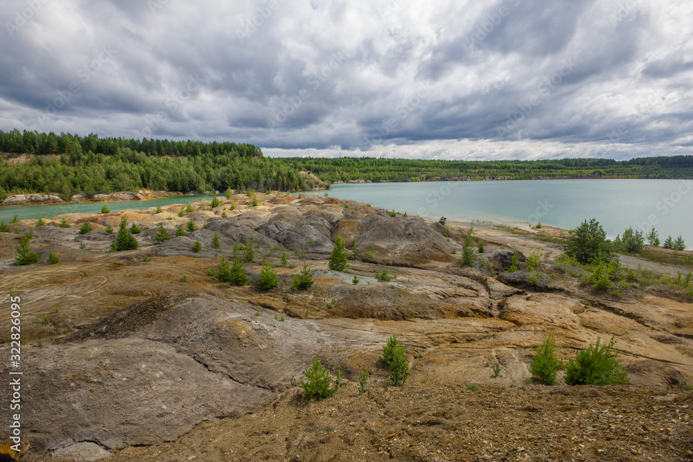 Flooded clay quarry lake with green water landscape