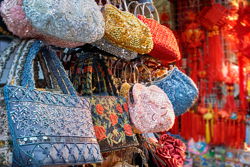 Colorful collection of heavy ornate hand bags displayed at street market in Shanghai.