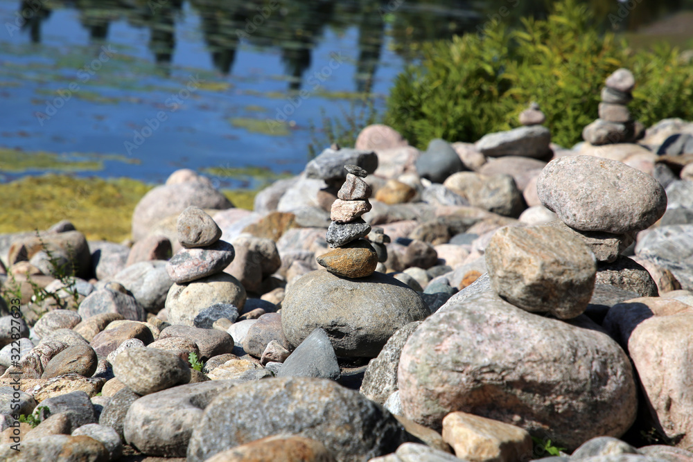 Stacks of natural rocks by the beach of lake Valkeinen in Kuopio, Finland. Beautiful inspiring zen like view to a garden with rocks by the water. Relaxing, simple view, perfectly peaceful and idyllic.