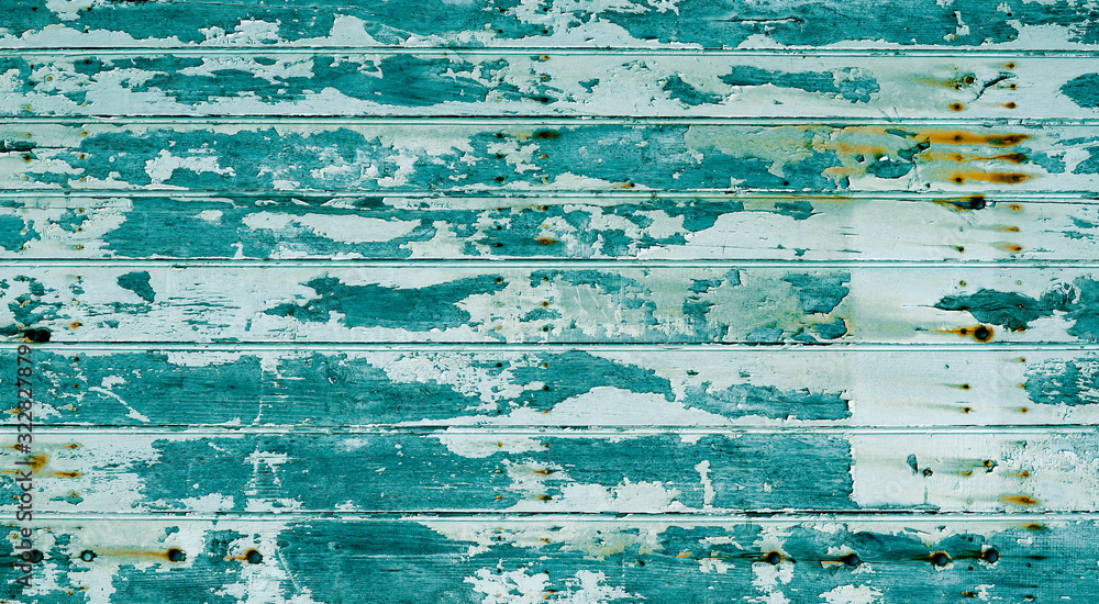 Old wood plank blue green texture with chipped white paint scratched and damaged by time with rusty stains from old nails as background, rustic wooden backdrop