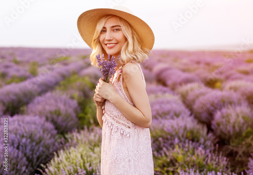 Cheerful woman with lavenders in field