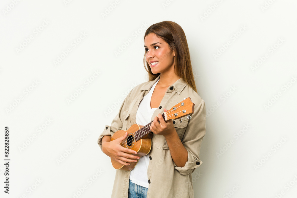 Young caucasian woman playing ukelele isolated Young caucasian woman playing ukelele isolated