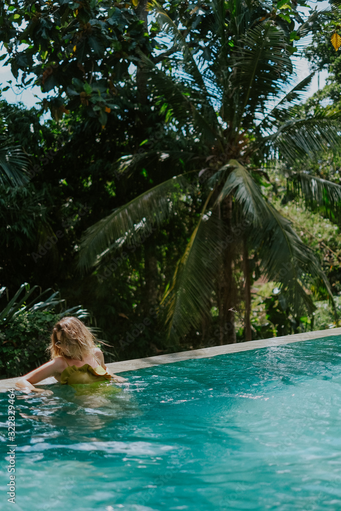 Young woman in infinity pool in the jungle in Ubud, Bali
