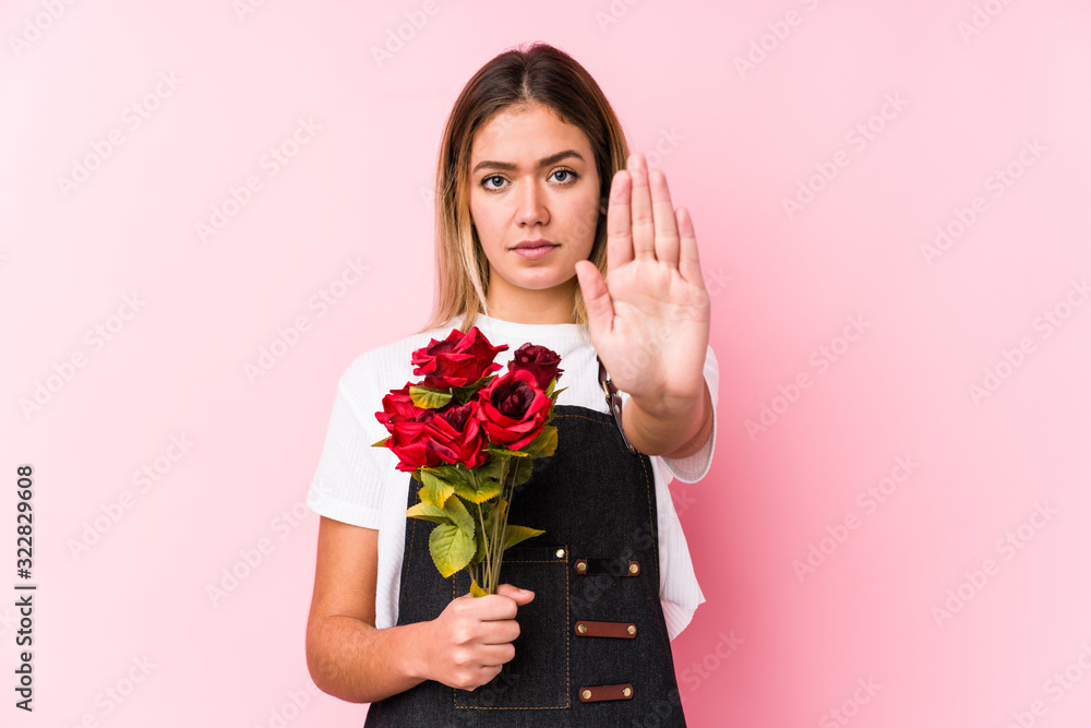 Young caucasian woman holding a roses isolated standing with outstretched hand showing stop sign, preventing you. Young caucasian woman holding a roses isolated standing with outstretched hand showing stop sign, preventing you.