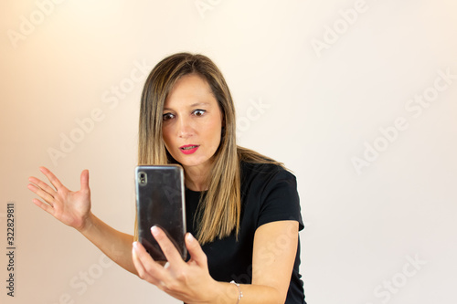 Young woman with mobile in hand surprised