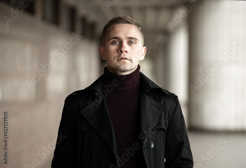 Stylish man in black trenchcoat photo