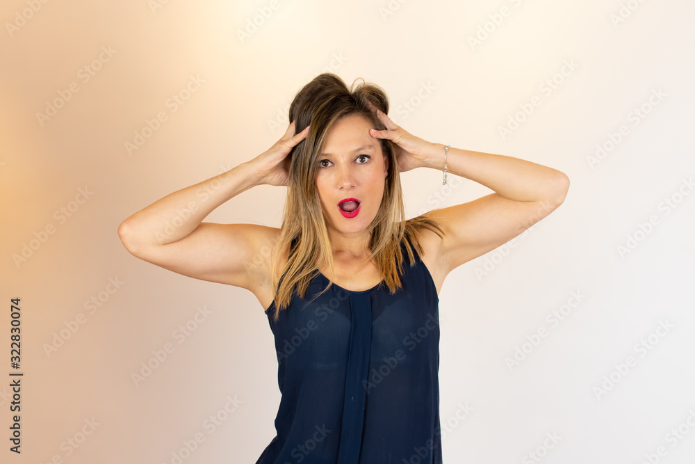 Fototapeta premium Young adult with her hands on her head surprised