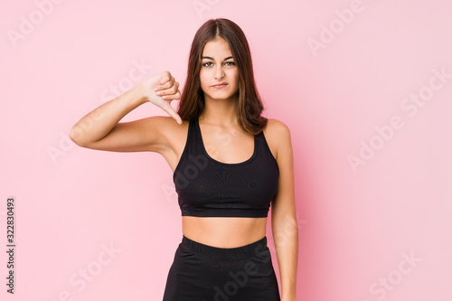 Young caucasian fitness woman doing sport isolated showing a dislike gesture, thumbs down. Disagreement concept.