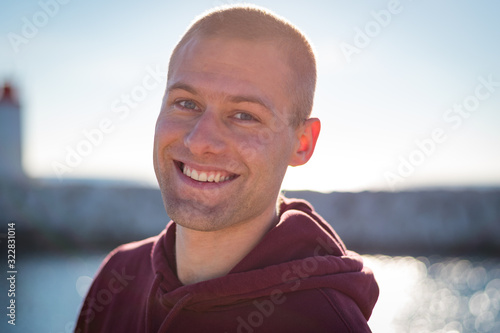 Portrait beau gosse charmant jeune homme caucasian blond aux yeux bleu joyeux et confiance en soi séduisant chanceux charismatique européen heureux zen motivation courage sourire joie moderne humble