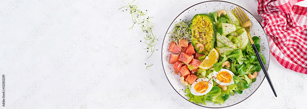 Ketogenic diet breakfast. Salt salmon salad with greens, cucumbers, eggs and avocado. Keto/paleo lunch. Top view, banner Ketogenic diet breakfast. Salt salmon salad with greens, cucumbers, eggs and avocado. Keto/paleo lunch. Top view, banner