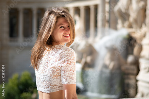 Portrait belle et charmante jeune femme pantalon à fleur caucasian brune aux yeux bleu joyeuse et confiance en soi séduisante chanceuse charismatique française européenne heureuse zen à parc marseille photo