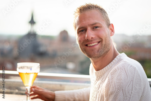 Portrait beau gosse charmant jeune homme caucasian blond aux yeux bleu joyeux et confiance en soi séduisant chanceux charismatique européen heureux zen à motivation rooftop toulouse photo