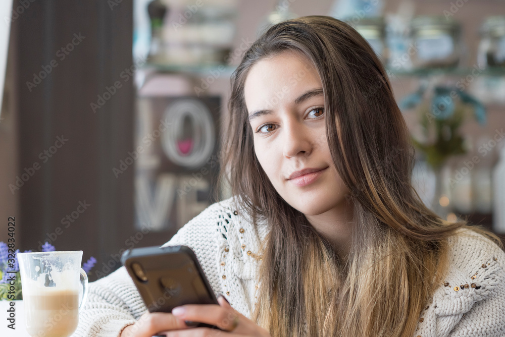 Portrait of a beautiful girl with a phone in a cafe. Portrait of a beautiful girl with a phone in a cafe.