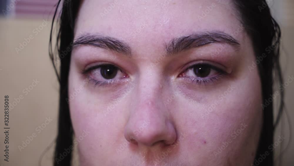 Slow blinking woman in shower looks from side to camera, Extreme Close Up Slow blinking woman in shower looks from side to camera, Extreme Close Up