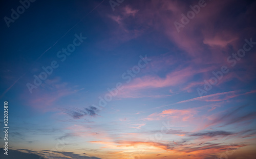 Blue sky during dawn with purple scattered clouds and orange sunset