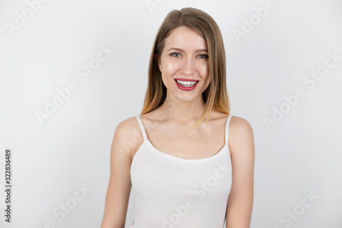 portrait of young beautiful blond woman looking happy and satisfied with her skin on isolated white background, healthcare and beauty concept