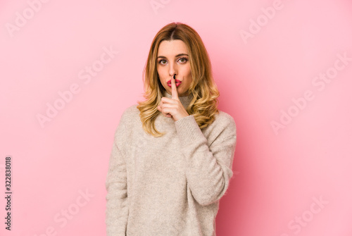 Young blonde cute woman wearing a sweater isolated keeping a secret or asking for silence.