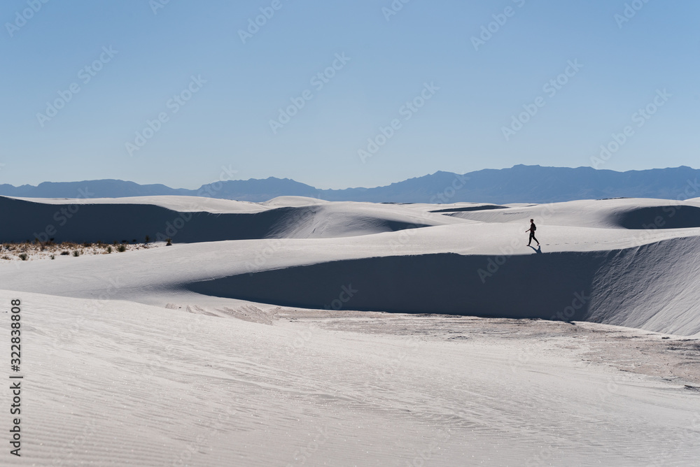 A man walking in the distance at White Sands National Park in Alamogordo, New Mexico. A man walking in the distance at White Sands National Park in Alamogordo, New Mexico.