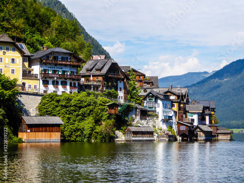 Small village located by the lake in Hallstatt, Austria. The houses have many different colors. Alpine village. Idyllic landscape. Coexistence of human and nature. High mountains rising from the lake