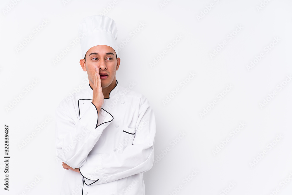 Young latin chef man isolated is saying a secret hot braking news and looking aside Young latin chef man isolated is saying a secret hot braking news and looking aside