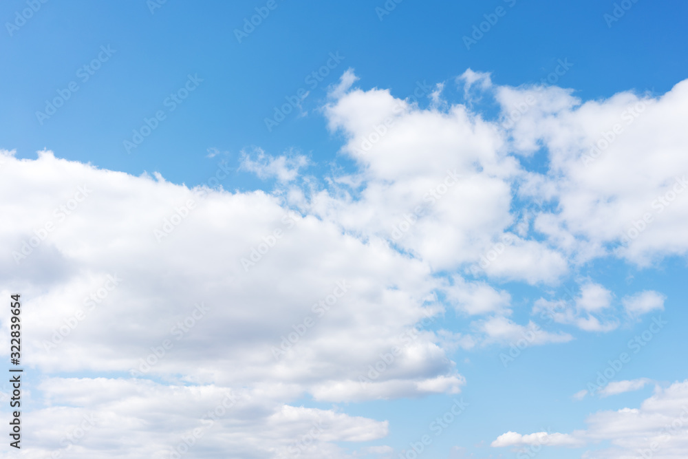 Fototapeta premium White cumulus clouds against the background against blue on a blue background.
