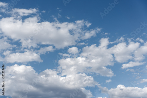 Fototapeta Naklejka Na Ścianę i Meble -  White cumulus clouds against the background against blue on a blue background.