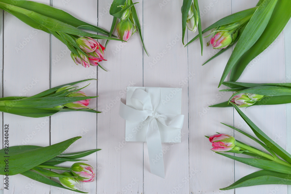 Obraz premium Valentines Day romantic background with white gift box and pinkTulips. Greeting card with pink Tulips .Spring card template. Women's Day. Greeting card for mother's day. Copy space. Selective focus
