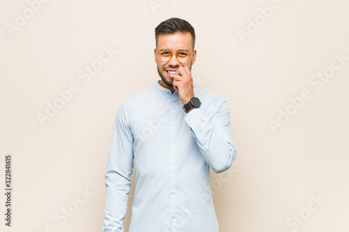 Young south-asian business man biting fingernails, nervous and very anxious. © Asier