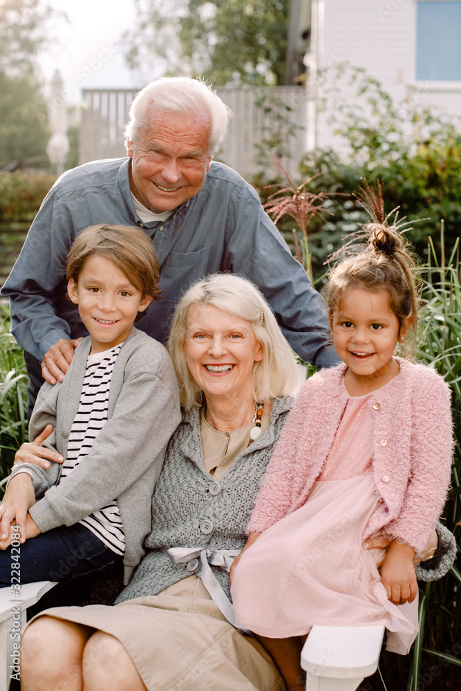 Portrait of grandparents and grandchildren sitting in backyard Portrait of grandparents and grandchildren sitting in backyard