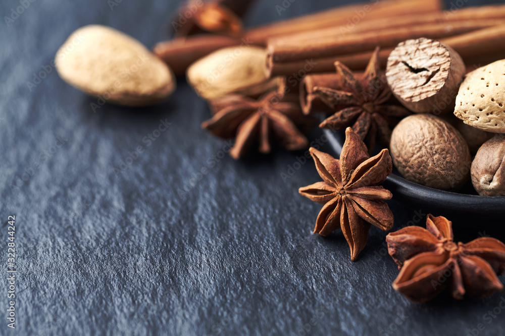 Star anise, nutmeg and cinnamon sticks on black stone background. Copy space. Star anise, nutmeg and cinnamon sticks on black stone background. Copy space.