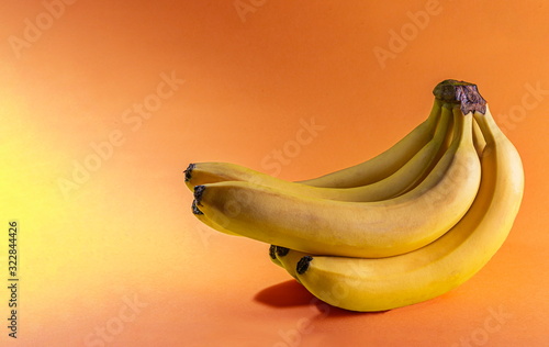 Bunch of ripe yellow bananas on a colored background. Diet fruit. Space for text.