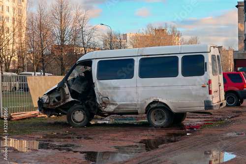 minibus parked in a parking lot with a burnt cab after an accident