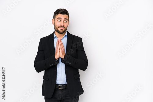 Young caucasian business man against a white background isolated making up plan in mind, setting up an idea.