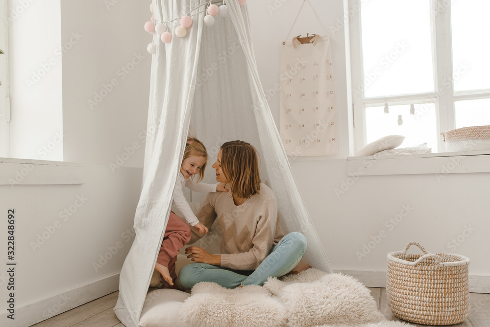 Cute baby girl with her mom play in a minimalistic children's room. Cute baby girl with her mom play in a minimalistic children's room.