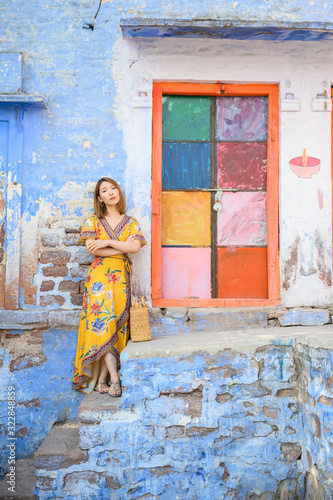 Portrait of young woman in front colorful blue tone building in Jodhpur the blue city in Rajasthan India © structuresxx