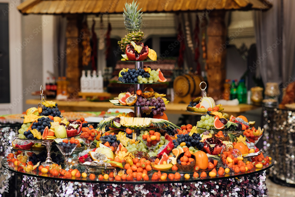  Wedding reception catering table with different fruits. Catering table with different kind of fruits. Various sweet sliced fruit on a buffet table. Different fresh fruits on wedding buffet table.