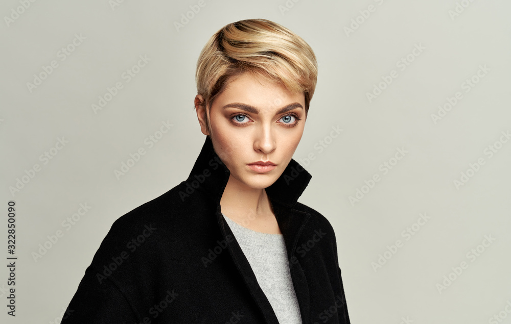 Portrait of sexy woman in blonde short hair isolated on gray background