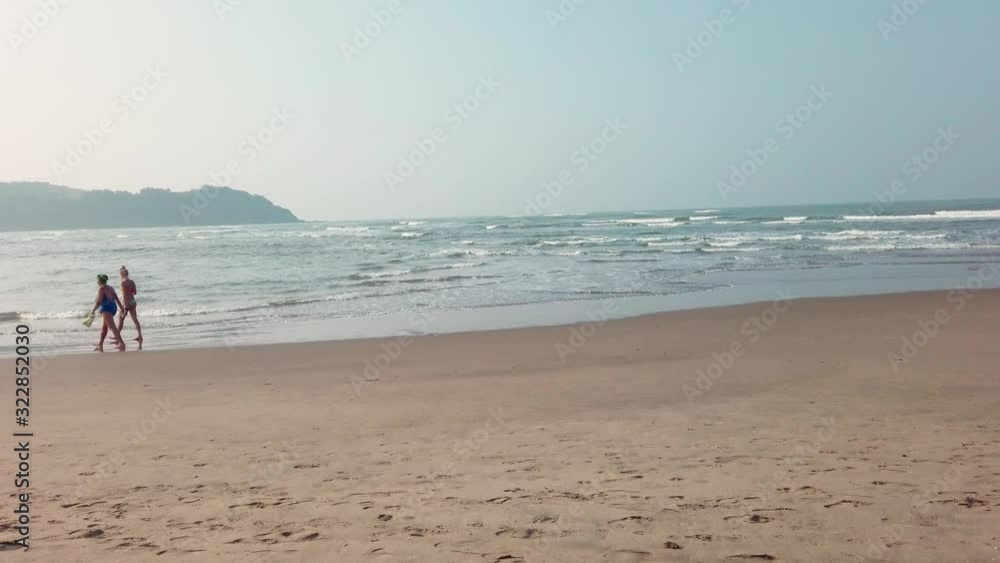The low tide from the sandy beach. Ocean waves are splashing on the shore. The low tide from the sandy beach. Ocean waves are splashing on the shore.