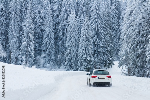 Car on winter road in snowy forest 