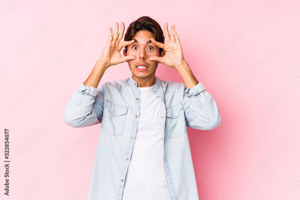Young caucasian man posing in a pink background isolated keeping eyes opened to find a success opportunity. Young caucasian man posing in a pink background isolated keeping eyes opened to find a success opportunity.