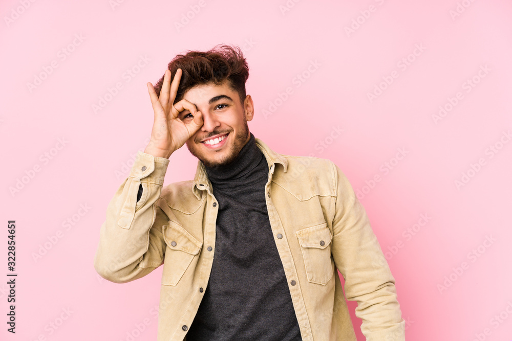 Young arabian man posing in a background isolated excited keeping ok gesture on eye. Young arabian man posing in a background isolated excited keeping ok gesture on eye.