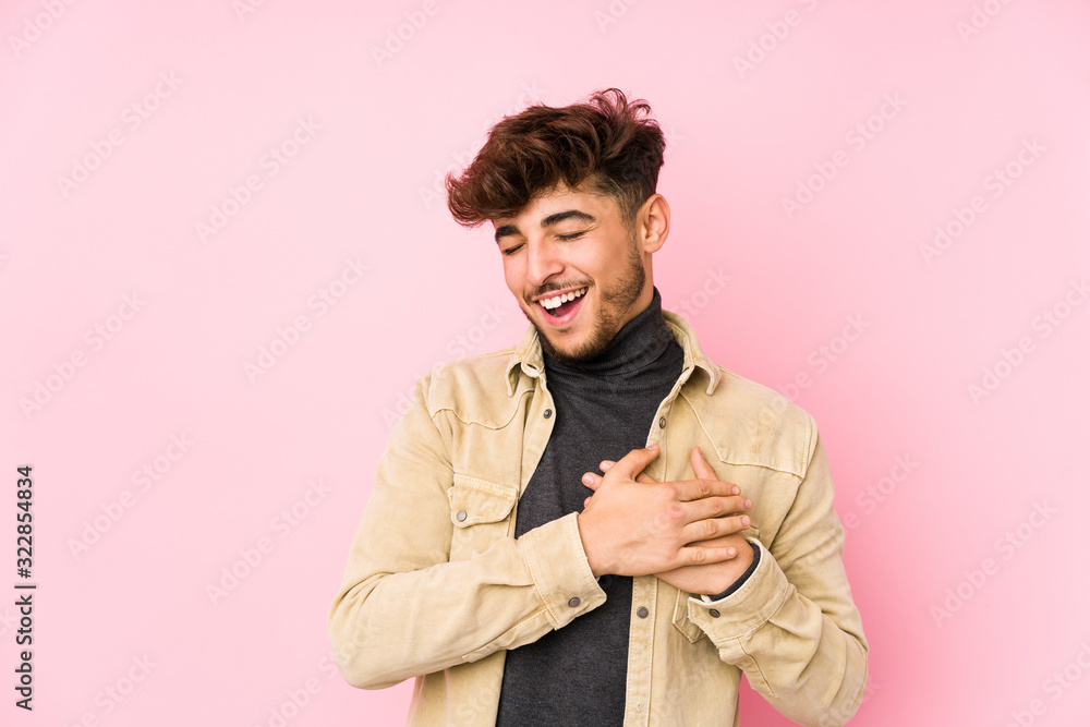 Young arabian man posing in a background isolated laughing keeping hands on heart, concept of happiness. Young arabian man posing in a background isolated laughing keeping hands on heart, concept of happiness.