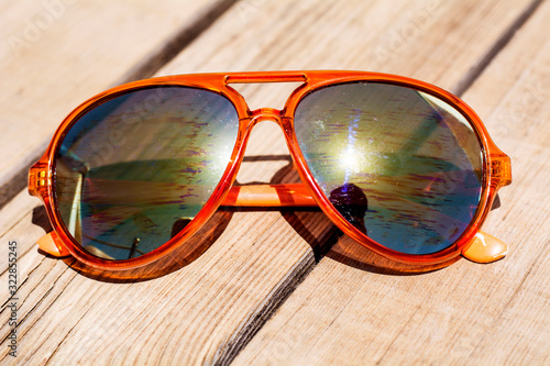 Fashion Golden Sunglasses on a Wooden Background. Summer Holiday Concept