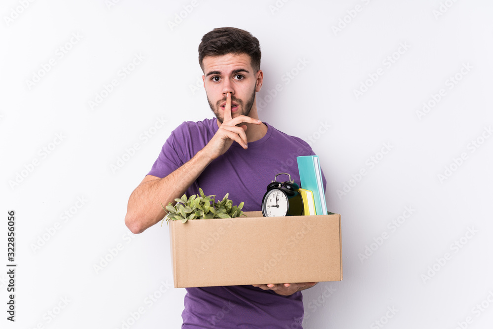 Young caucasian man moving a new home isolated keeping a secret or asking for silence. Young caucasian man moving a new home isolated keeping a secret or asking for silence.