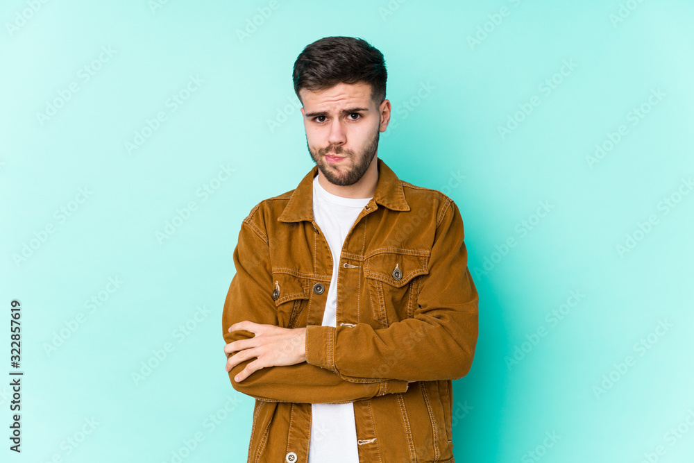 Young handsome man frowning face in displeasure, keeps arms folded. Young handsome man frowning face in displeasure, keeps arms folded.